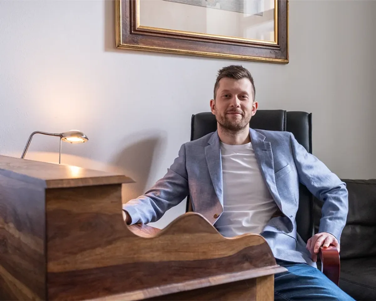 Porträt von Patrik Aksamit an seinem Schreibtisch